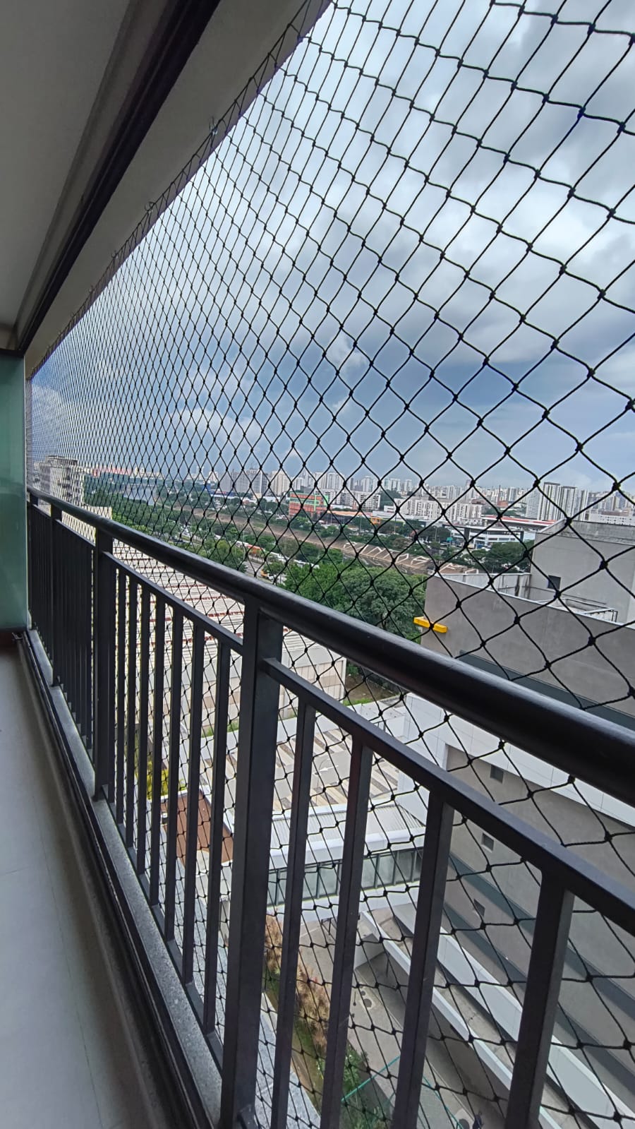 Rede de proteção escura instalada em varanda de apartamento